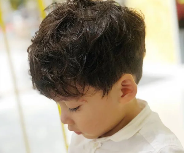 Bé trai với kiểu tóc uốn xoăn nhẹ tự nhiên