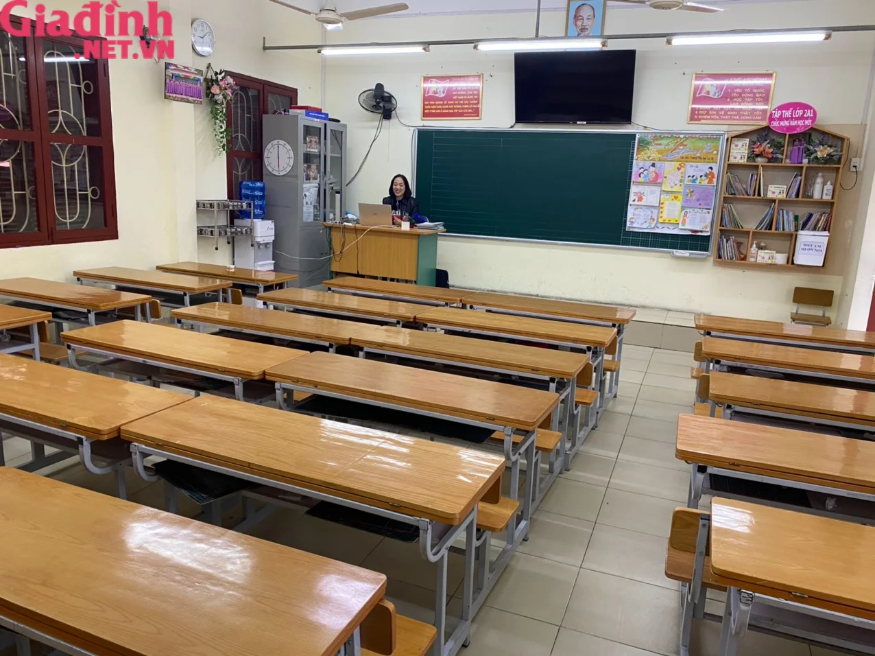 Không gian lớp học với các dãy bàn ghế gỗ và bảng xanh