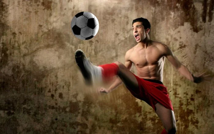 Ảnh đá bóng của một cầu thủ nam đang thực hiện cú sút trên sân tập