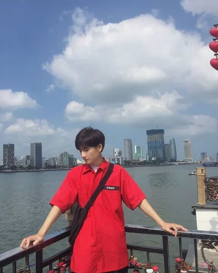 Chàng trai đẹp trai mặc áo đỏ nổi bật bên bờ hồ