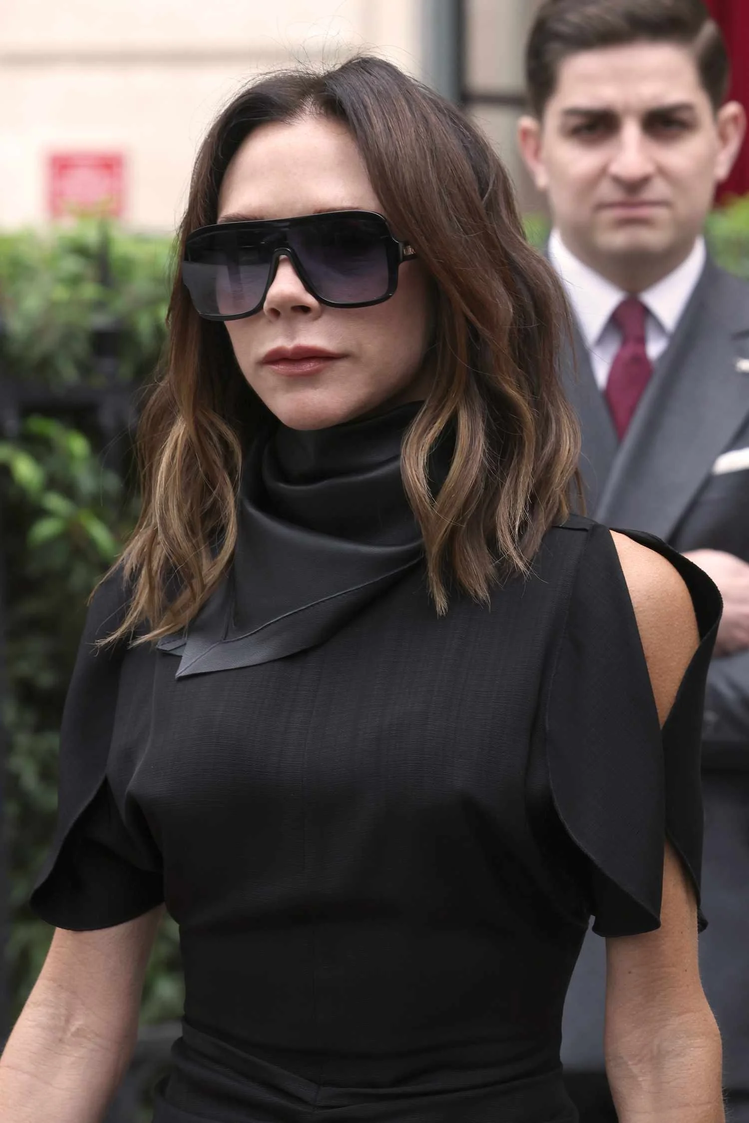 Victoria Beckham in a high neckline and oversize black sunglasses